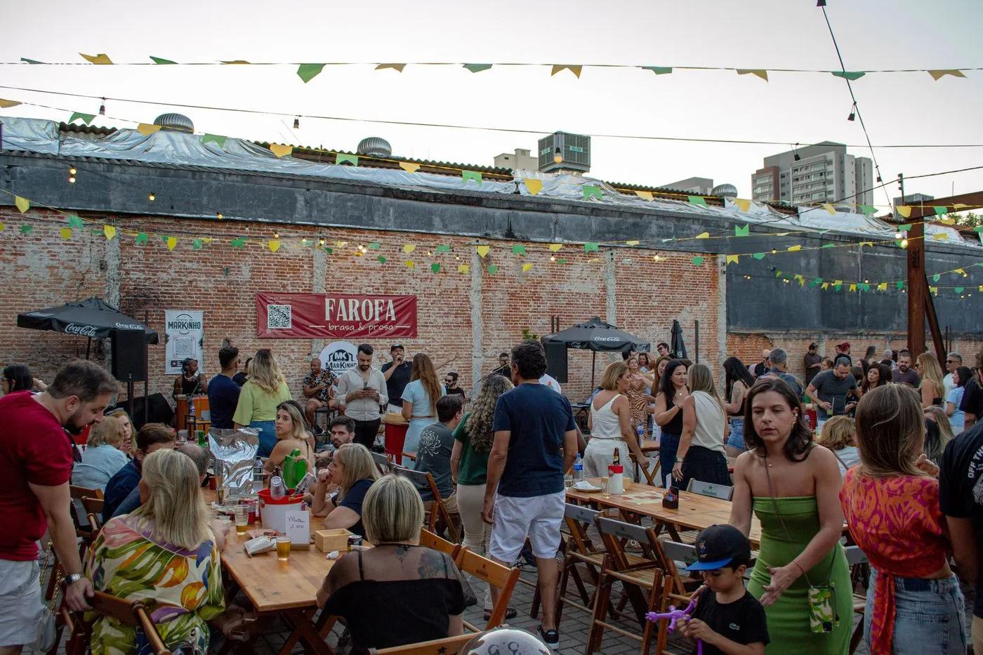 Festa no pátio do Farofa com convidados e bandeirinhas