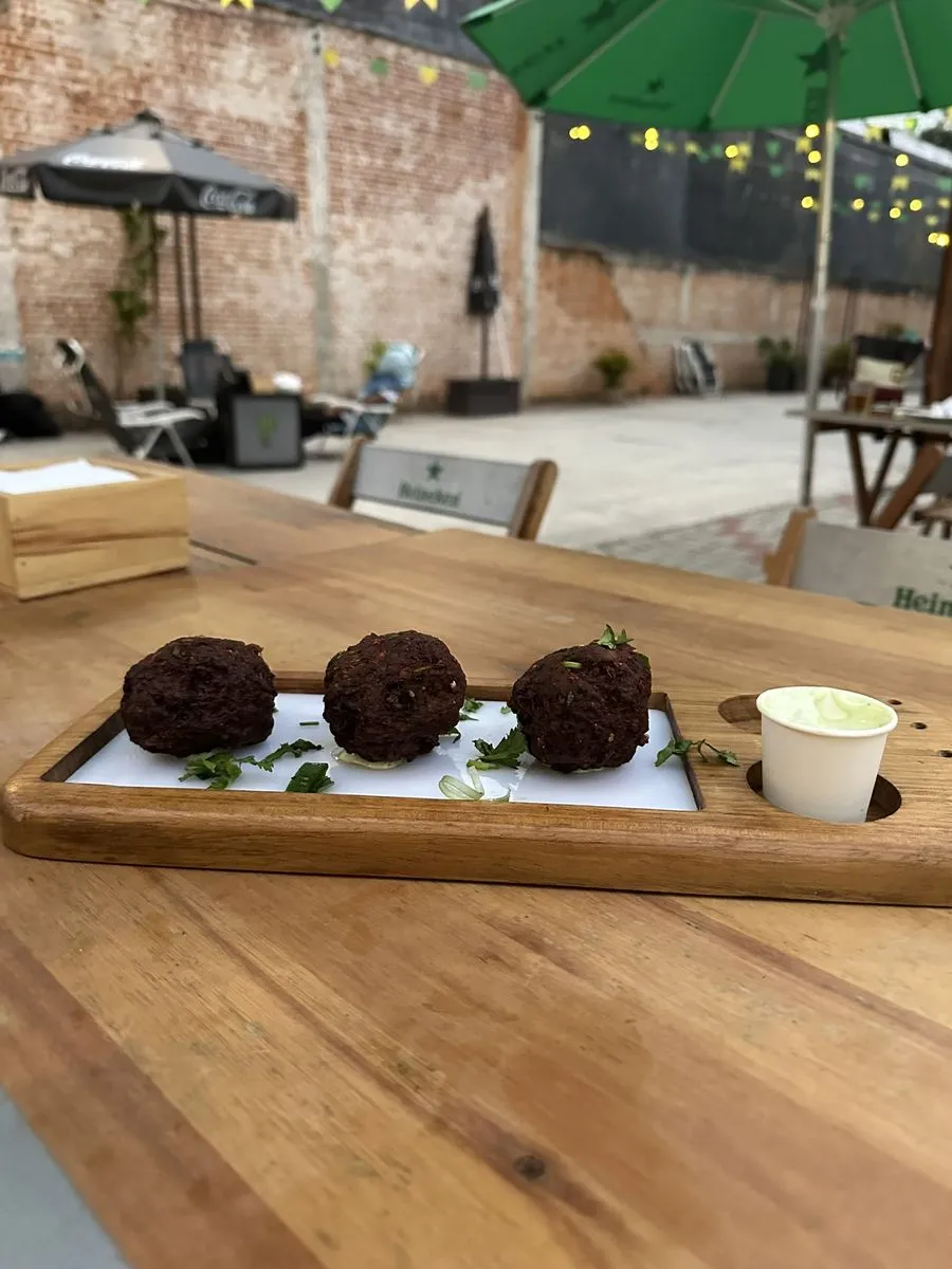 Porção de bolinhos servida na tábua de madeira